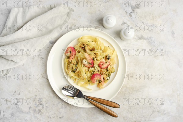 Fettuccine allo Scoglio, a delicious seafood pasta dish, is presented on a white plate with shrimp