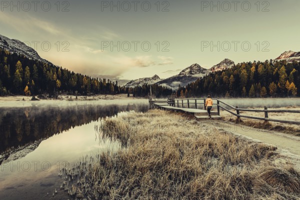Young woman at Lake Staz near Sankt Moritz in the Engadine in Switzerland. Morning atmosphere with