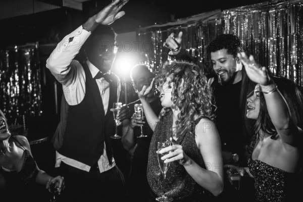 Group of stylish friends enjoying an exciting night out, dancing and sipping champagne at a lively