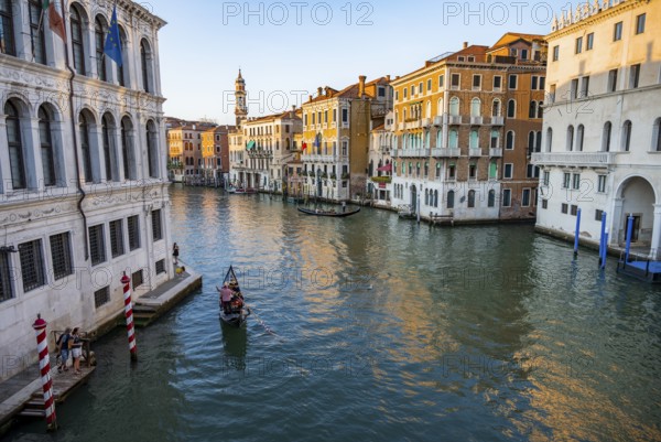 View of the Grand Canal with gondoliers at sunset, picturesque evening mood with palazzos on the