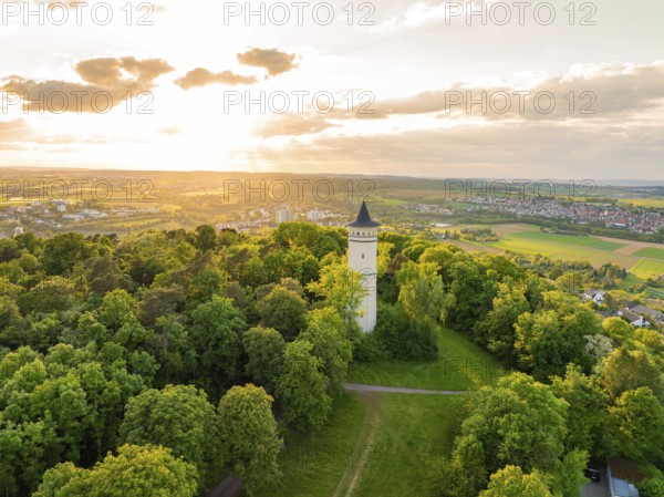 Tower with surrounding paths rises out of a green thicket under the sun, Engelberg Tower, Leonberg,