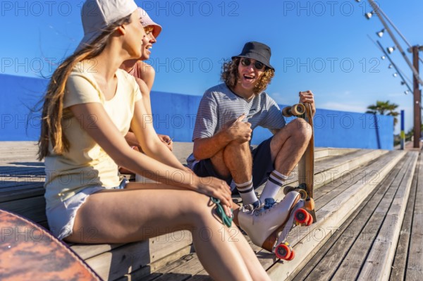 Group of young friends relaxing on wooden steps, enjoying a sunny day with skateboards, embodying a