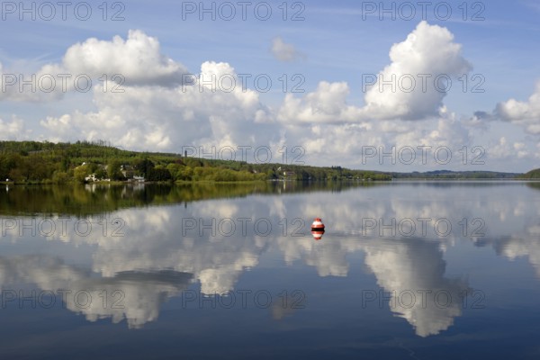 View over the Möhnesee, Möhnesee tower, red and white buoy, blue cloudy sky, reflection on the