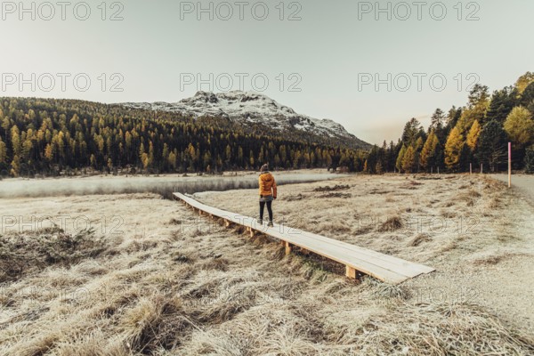 Young woman at Lake Staz near Sankt Moritz in the Engadine in Switzerland. Morning atmosphere with