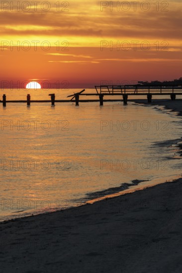 Sunset behind dilapidated fishing pier damaged by hurricanes on the Mississippi Gulf Coast in Long