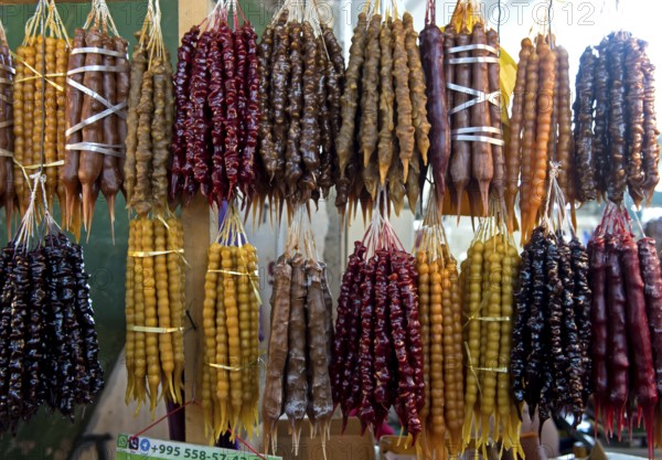 Traditional Georgian sweets Churchkhela made from walnuts and thickened grape juice, market stall