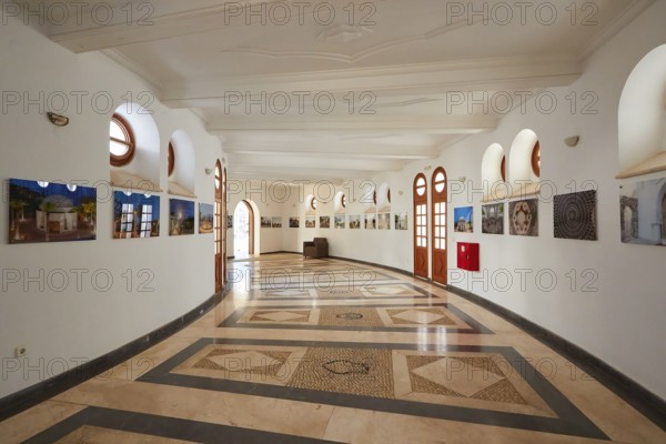 Elegant exhibition room with circular mosaic and photography on the curved wall, Kalithea,