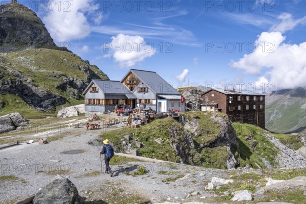 Mountaineer in front of mountain hut Cabane de Prafleuri in mountain landscape, Valais, Western