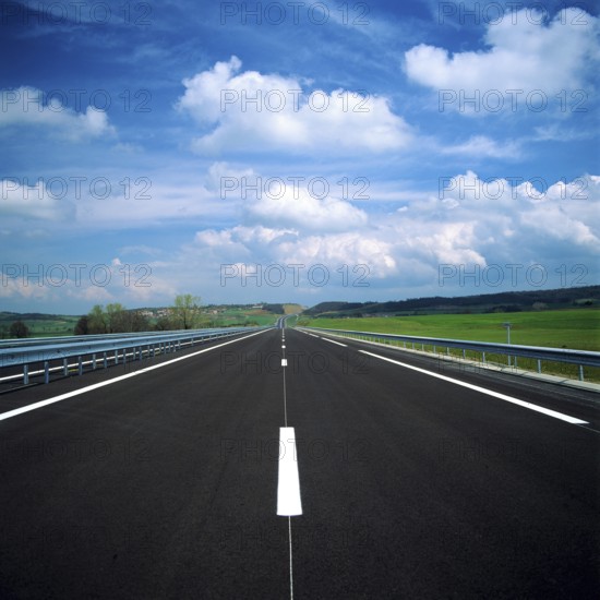A straight stretch of a French motorway showcases smooth asphalt and clear lane markings. Lush