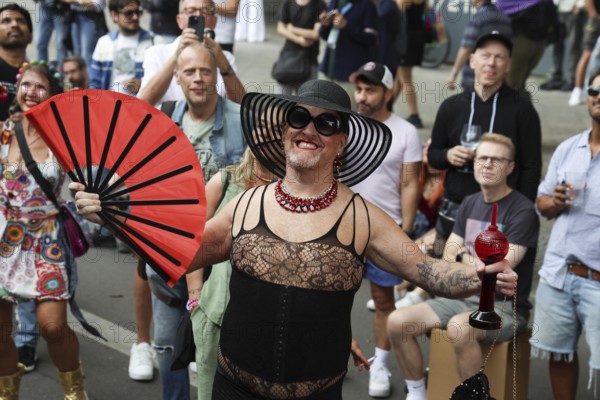 Man in net outfit with fan at the 47th Christopher Street Day under the motto Never again silent in