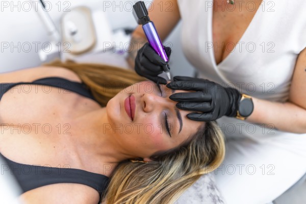 Beautician wearing black gloves using a dermopigmentation machine applying permanent eyeliner