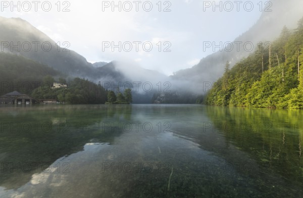 Mystical morning at Königssee in Schönau with boathouses and Christlieger. Sunrise and beautiful