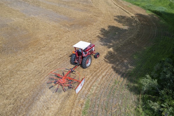 Wayland, Michigan - A farmer uses a rotary tedder to aerate his crop. A tedder spreads out hay or