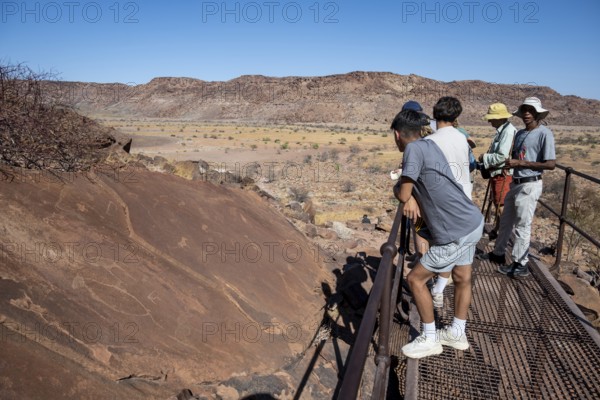Tourists with guide at the rock engravings of Twyfelfontein, Twyfelfontein, Kunene, Namibia