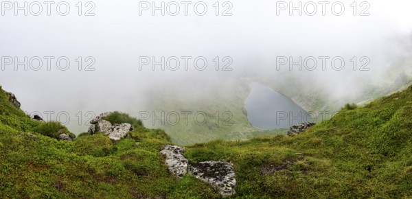 Wisps of mist drift over Kaltenbachsee, Schladminger Tauern, Sölktäler nature park Park, St.