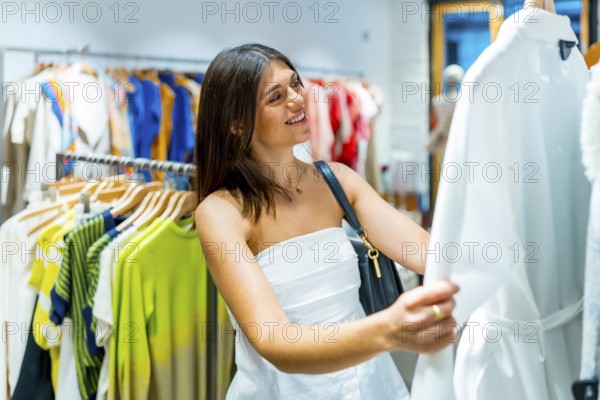 Happy customer smiling while holding a stylish white dress, enjoying the vibrant atmosphere of a