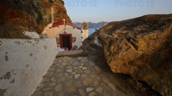 Legend, crab, shell fisherman, stone path to the chapel on the coast, surrounded by rocks, with