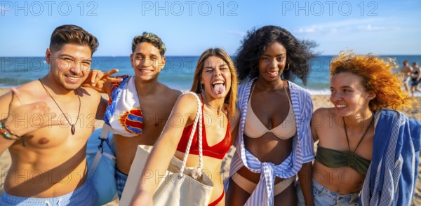 Five multi ethnic friends are having fun taking a selfie on the beach, sticking out their tongues
