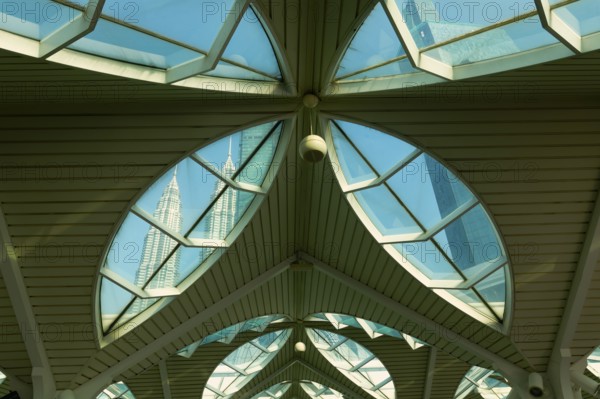 Petronas twin towers viewed through glass roofs of As Syakirin Mosque or KLCC Mosque, Kuala Lumpur,
