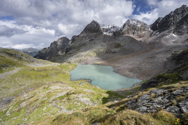 View of the turquoise-blue mountain lake Großer Gradensee, with the peaks of Petzeck and