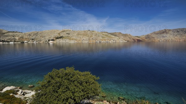 Clear bay surrounded by rocky hills under a blue sky, Bay of Emporio, Emporio, Symi, Dodecanese,