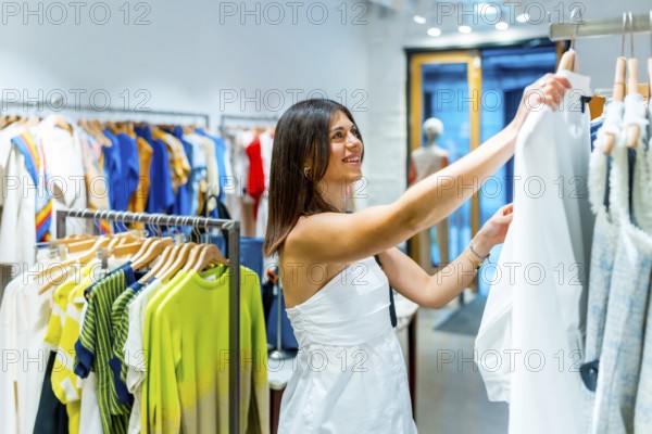 Smiling customer browsing colorful clothes on hangers in a vibrant fashion retail store, enjoying a