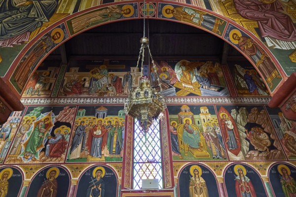 Artfully designed church interior with icons and large murals around a window, Church of the