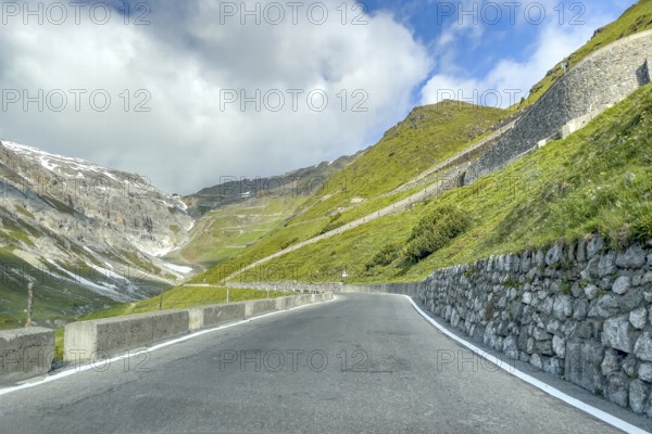 View of east ramp ascent to descent from Alpine pass Stelvio Stilfserjoch mountain road above tree