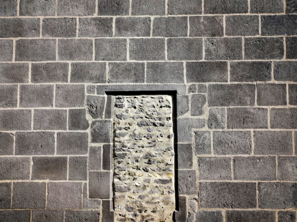 This structure features a stone wall of rough masonry with a distinct doorway outlined in