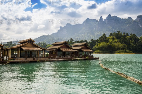 Floating houses on lake with jungle and rainforest and steep mountains, Cheow Lan Lake, Khao Sok