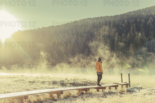 Young woman at Lake Staz near Sankt Moritz in the Engadine in Switzerland. Morning atmosphere with