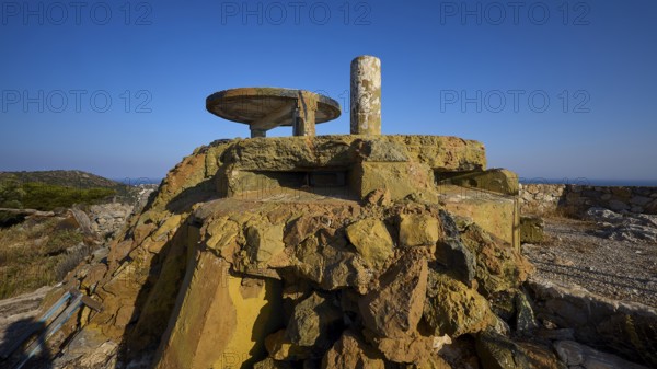 Dilapidated concrete structure on rocky ground with unobstructed view under a blue sky, Lost Place,