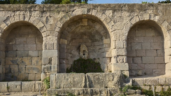 Three vaulted niches in an old stone wall in a historical site, retaining wall with niche, relief