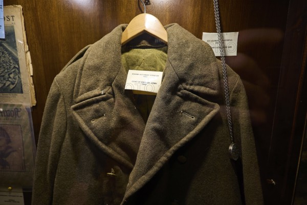 Old British military coat on a hanger in an illuminated wooden display case, War Museum, Military