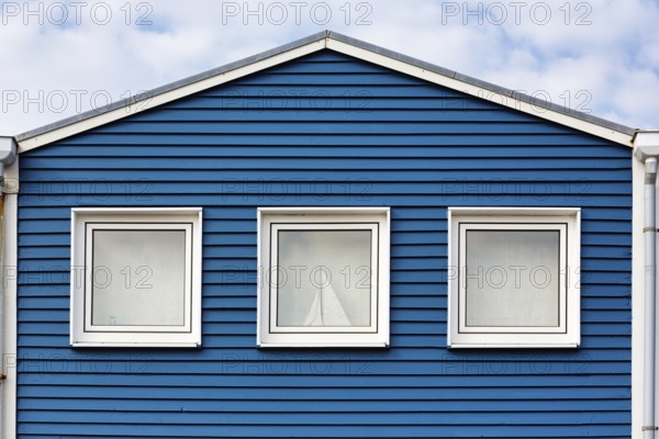 Blue lobster shack, wooden façade with three windows, façade detail in the harbour, Heligoland,