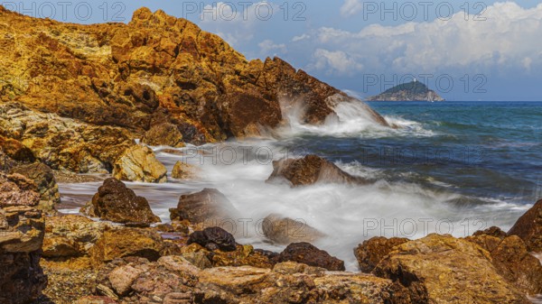 Rugged rocks and foaming spray on Topinetti beach, near Rio Marina, Elba Island, Tuscan Archipelago