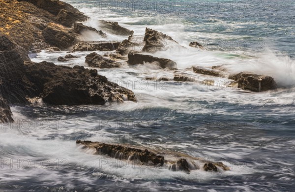 Rugged rocky coastline and foaming spray, on Stecci beach, near Capoliveri, Elba Island, Tuscan