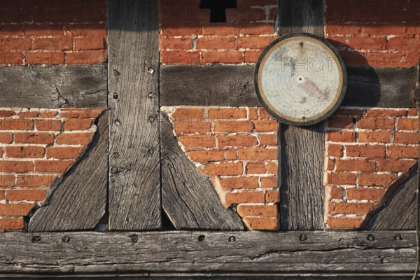 An old target hangs on the outside wall of a farmhouse, half-timbered, historical, Böhme,