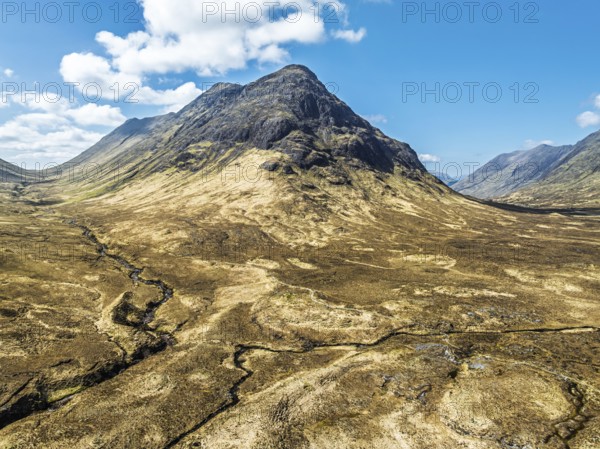 Buachaille Etive Beag and Three Sisters in Glencoe over Moors and Road A82 from a drone, Highlands,