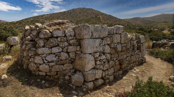 Sky exchanged, Large stone wall in an unspoilt mountain landscape with cloudy sky and surrounded by