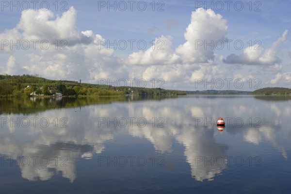 View over the Möhnesee, Möhnesee tower, red and white buoy, blue cloudy sky, reflection on the