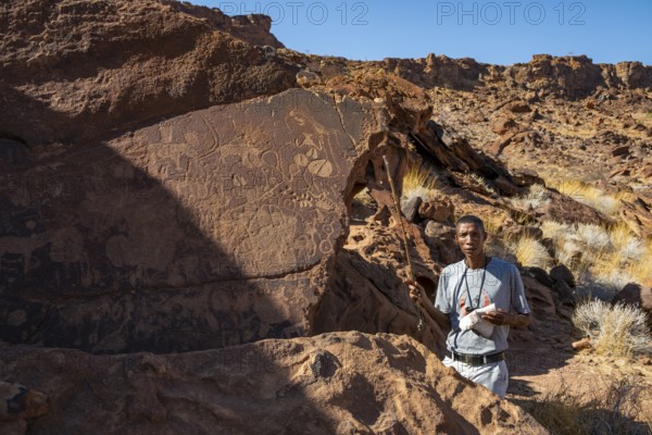 Tourist guide explains the details of the rock engravings at Twyfelfontein, Twyfelfontein, Kunene,