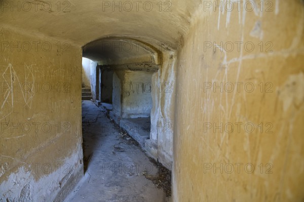 Long corridor with weathered walls leading into the darkness, mysterious and abandoned, Italian