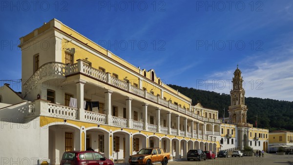 Yellow building with balconies, vehicles in front, blue sky in the background, Holy Week, Bay of