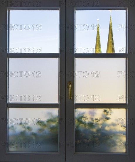 View through a closed window to the collegiate parish church of St Philip and St James, place of