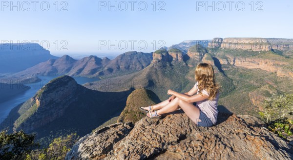 Hiker enjoying sunset at Blyde River Canyon with Three Rondawels peak, view of canyon with Blyde