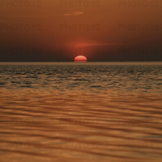 When the red sun sinks into the sea... Cuxhaven, North Sea, sunset in calm weather, glowing red