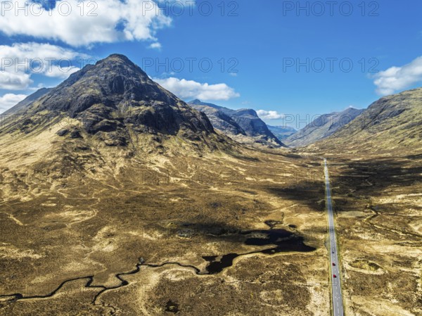 Buachaille Etive Beag and Three Sisters in Glencoe over Moors and Road A82 from a drone, Highlands,