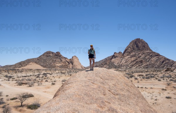 Tourist with camera, rock formation, Pontok Mountains, Spitzkoppe, Große Spitzkuppe Nature Reserve,