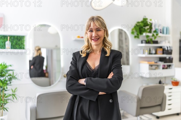 Beautician smiling confidently with crossed arms, posing in her modern beauty salon, engaging with